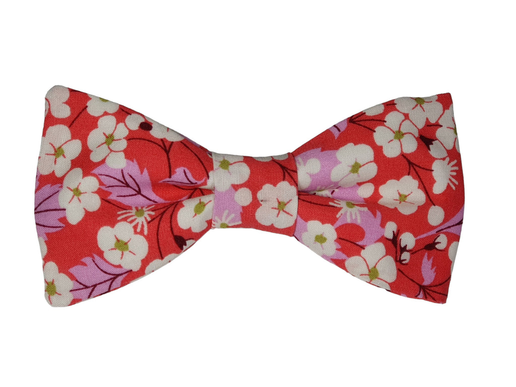 Nœud papillon liberty corail à fleurs blanches, accessoire élégant pour mariage et tenue chics.