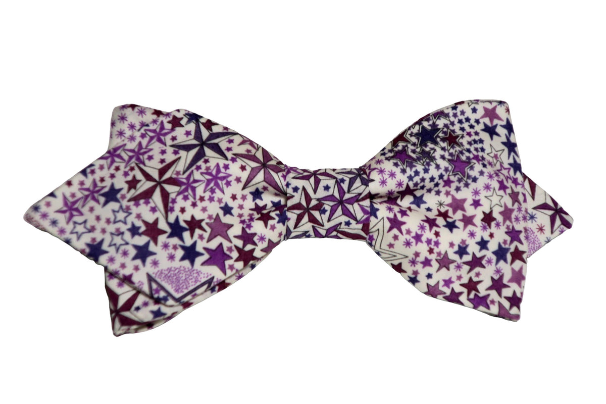 Nœud papillon Liberty dans des nuances de violet et bordeaux, orné d'un délicat motif étoiles : une évasion vers l'élégance bohème.