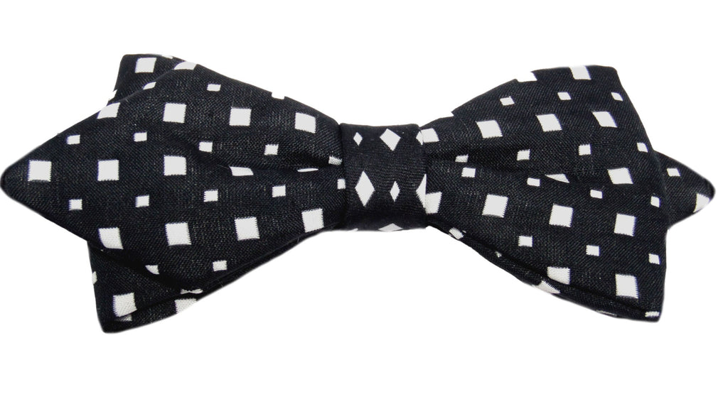 Nœud papillon noir agrémenté de petits carrés blancs : une alliance classique et intemporelle. Ce nœud papillon incarne l'élégance sobre avec sa teinte noire profonde, tandis que les petits carrés blancs apportent une touche subtile de raffinement