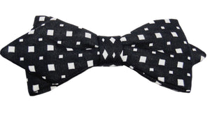 Nœud papillon noir agrémenté de petits carrés blancs : une alliance classique et intemporelle. Ce nœud papillon incarne l'élégance sobre avec sa teinte noire profonde, tandis que les petits carrés blancs apportent une touche subtile de raffinement