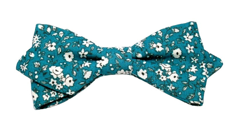 Dans un éclatant mélange de sophistication et de fraîcheur printanière, ce nœud papillon vert canard se pare de délicates fleurs blanches